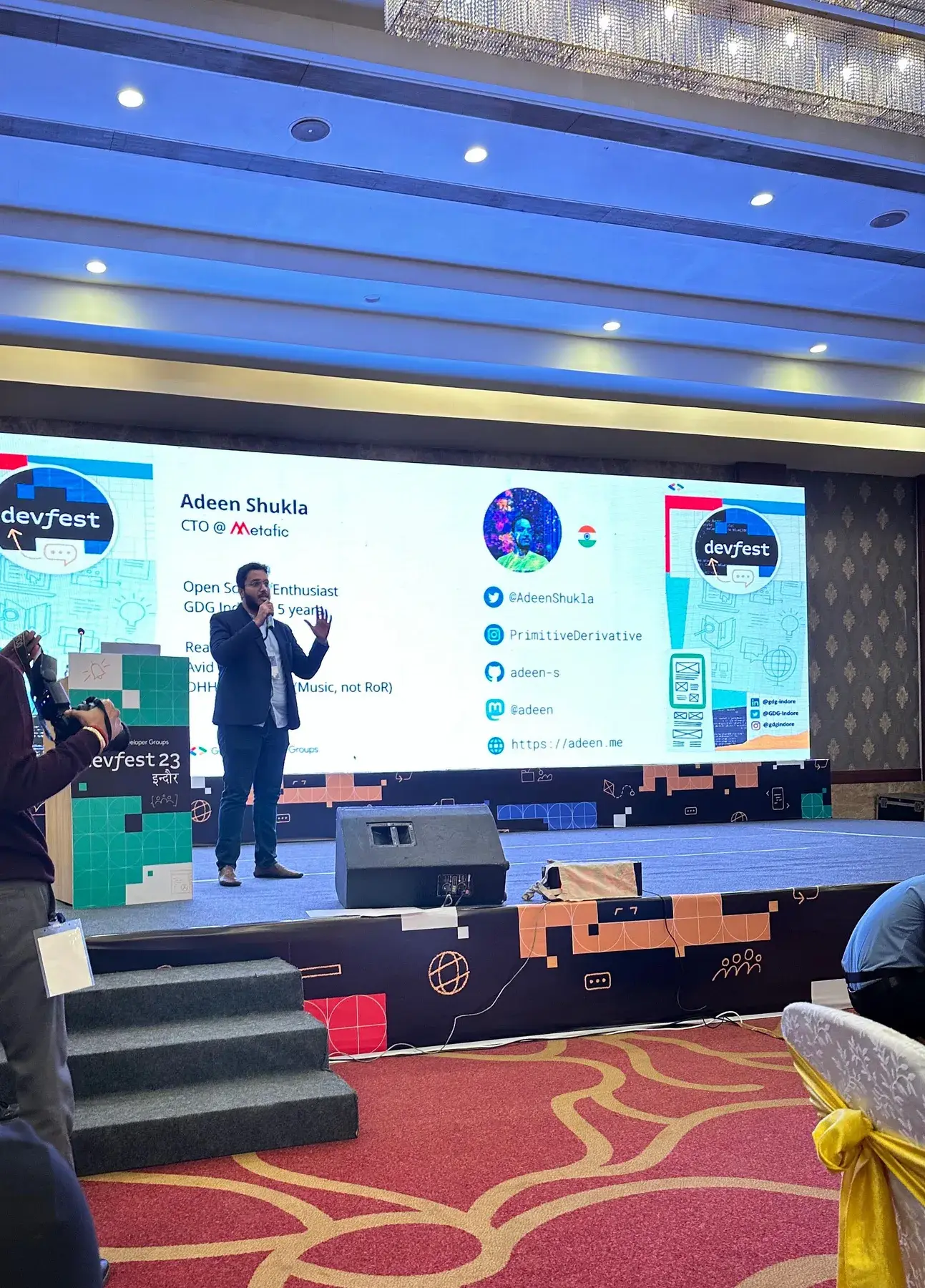 Adeen on stage at DevFest '23 Indore, his profile on the big screen